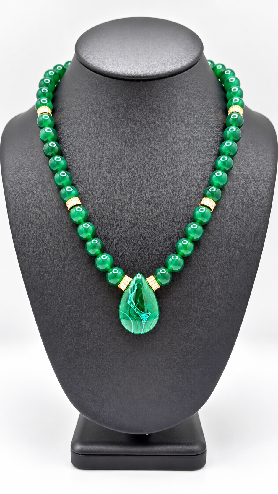 Malakita Unisex green beaded necklace with gold-tone accents and a green leaf pendant on a black display bust