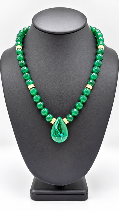 Malakita Unisex green beaded necklace with gold-tone accents and a green leaf pendant on a black display bust