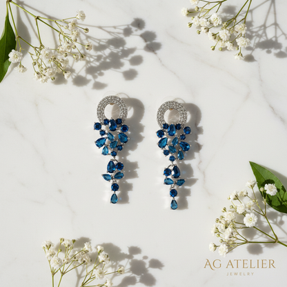 Midnight Sapphire Earrings flat lay on marble with flowers